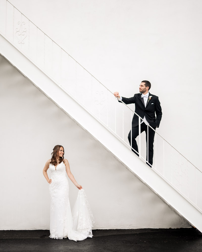 Bride and groom in an editorial pose on a fire escape outside of the WIlliam Penn Inn