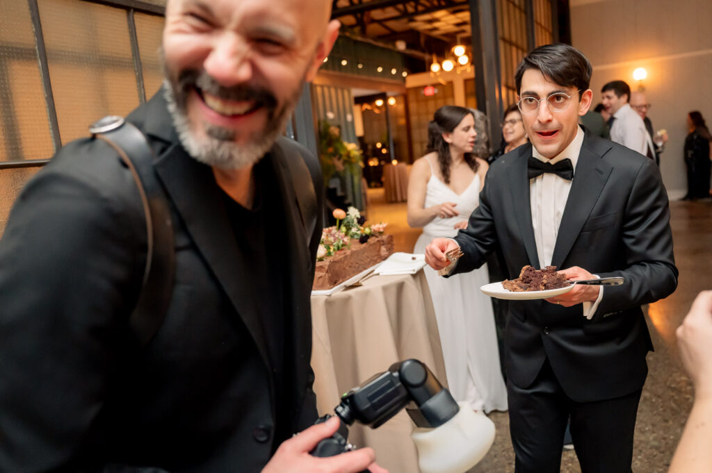 Wedding couple feeds photographer cake