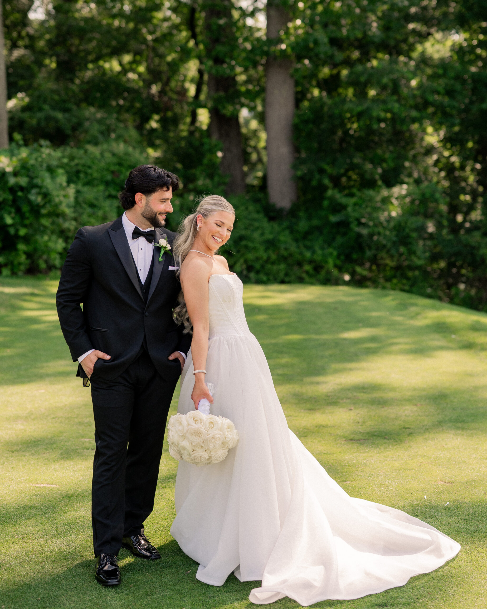 Bride and groom laugh with each other during their portrait session at Paxon Hollow Country Club in Broomall, PA