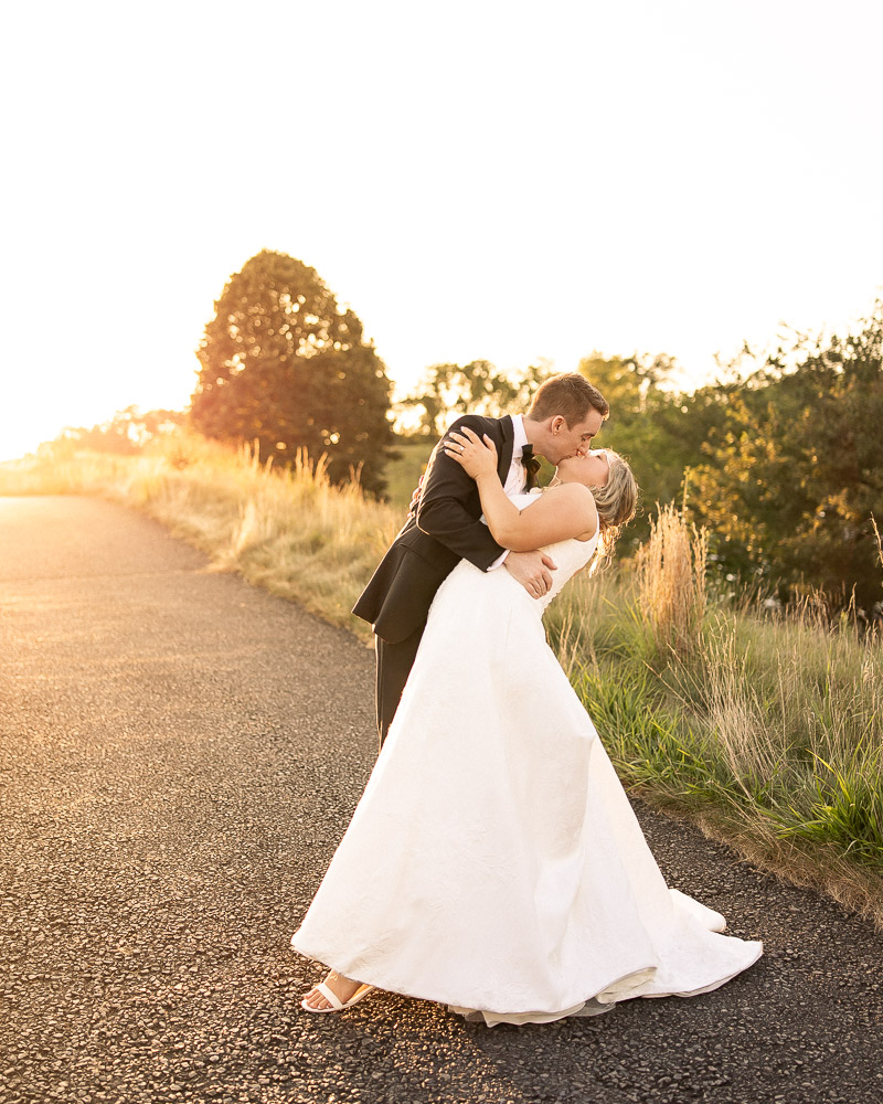 bride and groom kiss during golden hour at their French Creek Golf Club Wedding